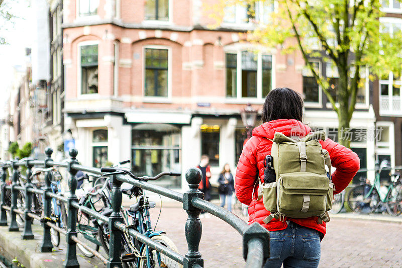 在阿姆斯特丹Zaanse Schans旅游期间使用手机的亚洲女性